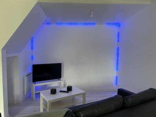 un salon avec un canapé et une télévision dans l'établissement Le Voltaire, à Dijon