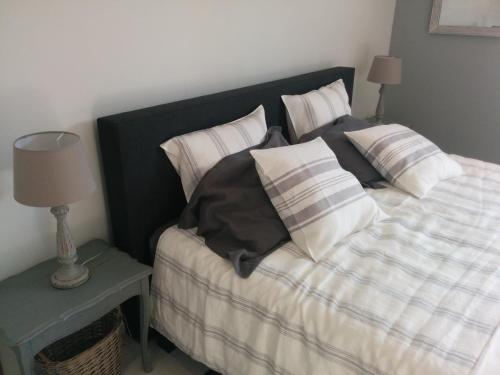 a bed with a black and white comforter and pillows at La Couette de l'Ours in Aywaille