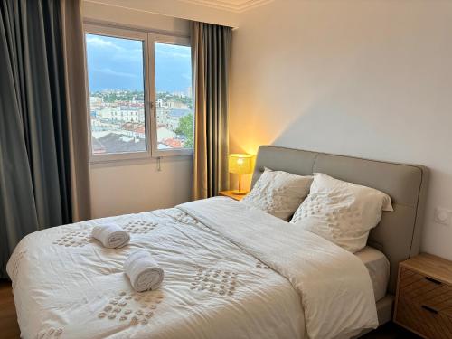 une chambre avec un lit blanc avec une grande fenêtre dans l'établissement 123 - Appartement spacieux pour 8 personnes à Paris, à Paris