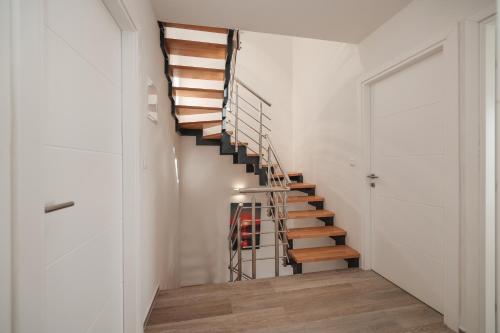 a staircase in a home with white walls and wooden floors at Villa Miri III in Privlaka