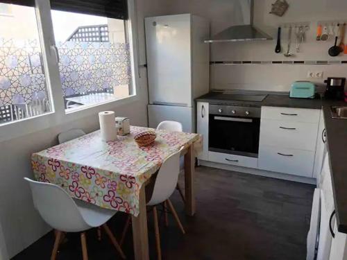 a kitchen with a table and chairs and a kitchen with a stove at Real 1H in Las Casas