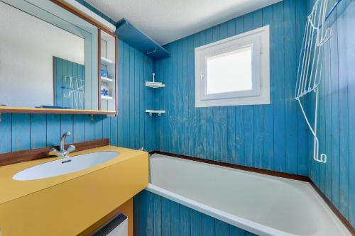Baño azul con lavabo y bañera en Vue sur le port du Crouesty, appartement pour 5, en Arzon