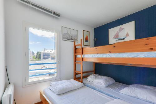 Dos literas en una habitación con ventana. en Vue sur le port du Crouesty, appartement pour 5, en Arzon