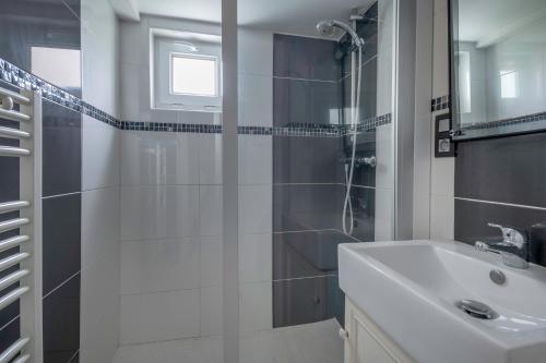 a white bathroom with a shower and a sink at 280m de la plage, appartement pour 4 in Saint-Michel-Chef-Chef