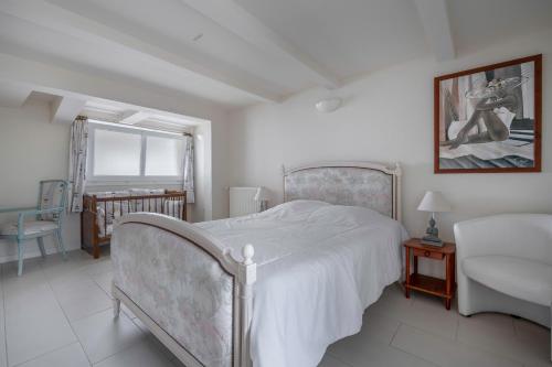 a white bedroom with a bed and a sink at 280m de la plage, appartement pour 4 in Saint-Michel-Chef-Chef