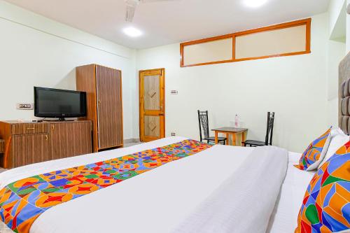 a bedroom with a bed and a flat screen tv at FabHotel Grand Comforts in Haidarpur