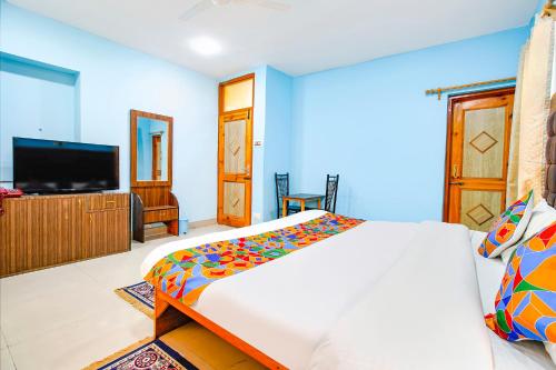 a bedroom with a bed and a flat screen tv at FabHotel Grand Comforts in Haidarpur