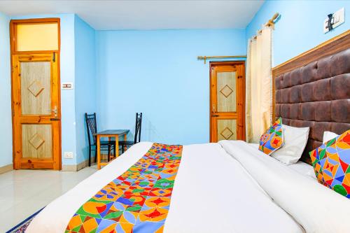 a bedroom with a large bed with a colorful blanket at FabHotel Grand Comforts in Haidarpur