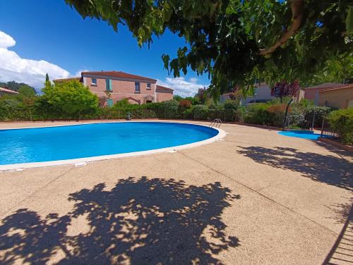 une grande piscine devant une maison dans l'établissement Maison provençale avec piscine partagée, à Loriol-du-Comtat