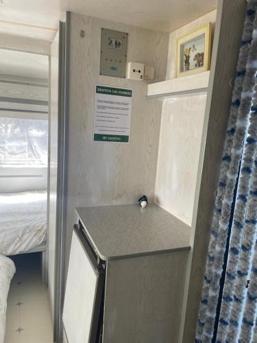 a small room with a bed and a sign on the wall at Mi Cachito in Los Caños de Meca
