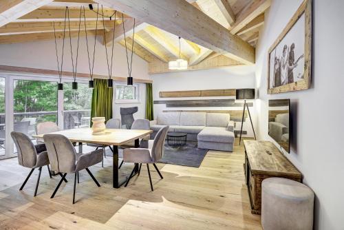 a dining room and living room with a table and chairs at Das Förstereck in Viehhofen