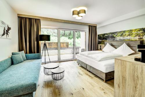 a hotel room with a bed and a couch at Das Förstereck in Viehhofen