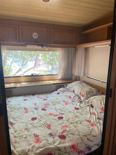a bed in an rv with a floral comforter at Mi Cachito in Los Caños de Meca