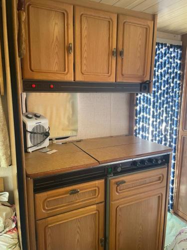 a kitchen with wooden cabinets and a stove at Mi Cachito in Los Caños de Meca