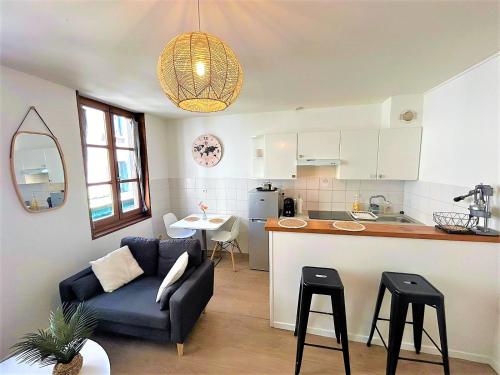 a living room and kitchen with a couch and a table at Appartement à 150 m de la cathédrale in Rodez