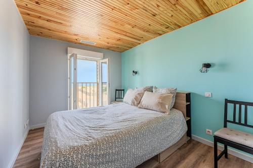 ミミザンにあるMaison Bord De L'Océan 3 étoilesの木製の天井のベッドルーム1室(ベッド1台付)