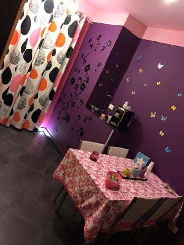 a dining room with a table and a purple wall at B&B Dolce Sogno in SantʼElpidio a Mare