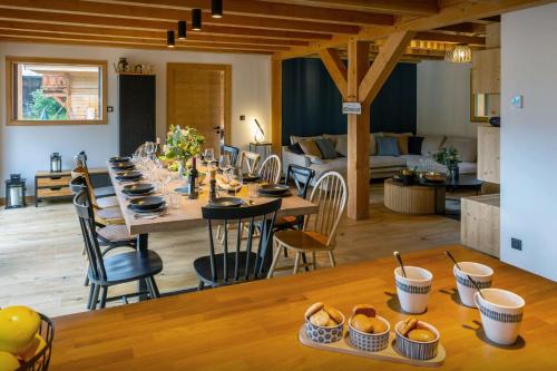 Una larga mesa de comedor con sillas y una sala de estar. en Chalet Lezopau - OVO Network, en Samoëns