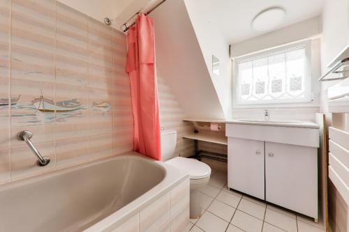 a bathroom with a tub and a toilet and a sink at À 350m du bord de mer, maison pour 4 in Saint-Pierre-Quiberon