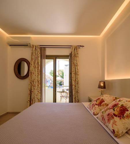 a bedroom with a large bed and a window at Zephyros Hotel in Kamari