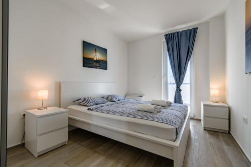 a bedroom with a large bed with two night stands at Villa Miri III in Privlaka