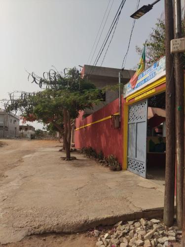 a building on the side of a dirt road at Auberge Africa Thiossane in Saly Portudal