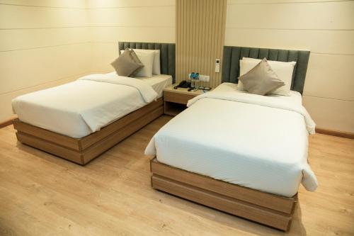 two beds sitting next to each other in a room at Pan Asia Continental in Kolkata