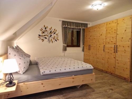 a bedroom with a bed and wooden cabinets at Ferienwohnung " Esserhof " Nationalpark Gesäuse in Ardning