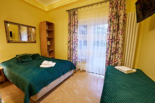 a bedroom with a green bed and a window at Majątek Giże Marczak in Olecko