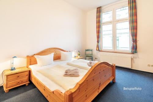 a bedroom with a wooden bed and a window at Haus Zander in Heringsdorf
