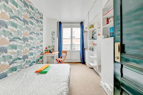 une petite chambre avec un lit et un bureau dans l'établissement Petit studio cosy à Saint-Germain-Des-Prés et Jardin du Luxembourg, à Paris