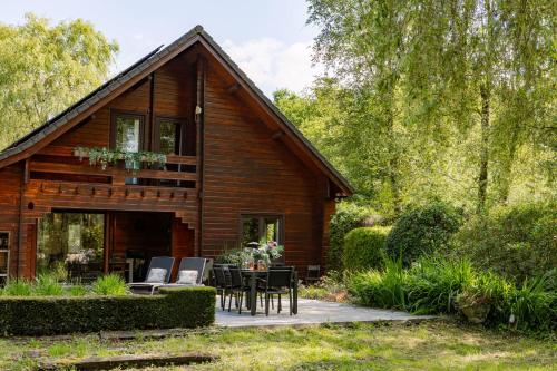 a log cabin with a table and chairs in front of it at Huswell - Tranquil retreat, cozy chalet in the heart of Urse in Aalter