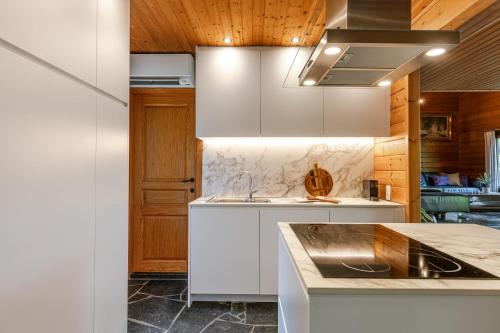 a kitchen with white cabinets and a sink at Huswell - Tranquil retreat, cozy chalet in the heart of Urse in Aalter