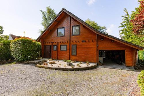 a large wooden house with a courtyard in front of it at Huswell - Tranquil retreat, cozy chalet in the heart of Urse in Aalter