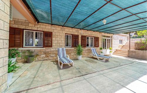 a patio with two chairs and a blue ceiling at Holiday Home Prigradica With Fireplace 06 in Prigradica