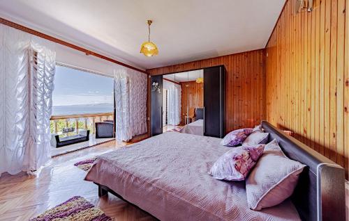 a bedroom with a large bed and a balcony at Holiday Home Prigradica With Fireplace 06 in Prigradica