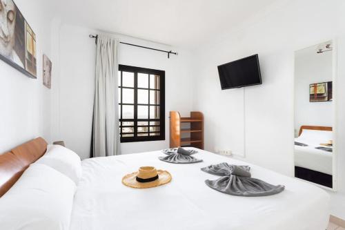a bedroom with a white bed with a hat on it at Volcanoes and Ocean Views in Arona