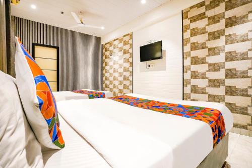 a hotel room with a bed and a tv at FabHotel Prime Welcome Palace in Surat