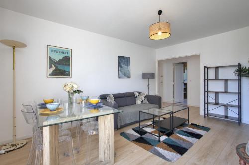 un salon avec un canapé et une table dans l'établissement Appartement des Chênes - Welkeys, à Anglet