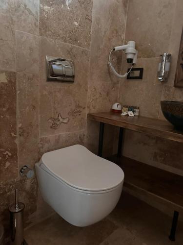 a bathroom with a white toilet and a sink at Hira Cave Hotel in Goreme