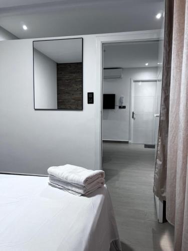 a white room with a bed and a mirror at New apartment in Al Hoceïma