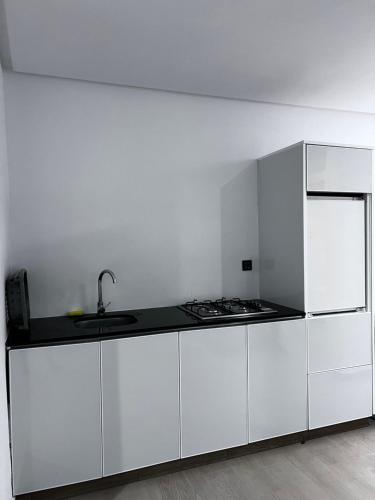 a white kitchen with a sink and a refrigerator at New apartment in Al Hoceïma