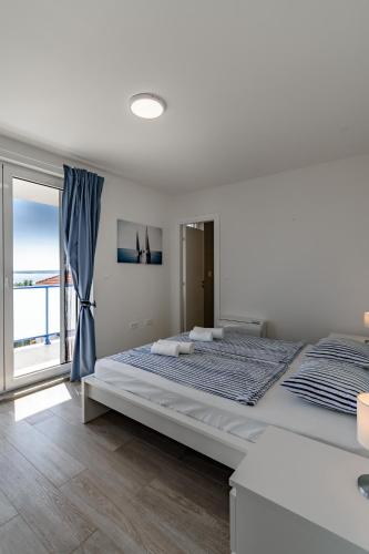 a bedroom with a large bed and a large window at Villa Miri III in Privlaka