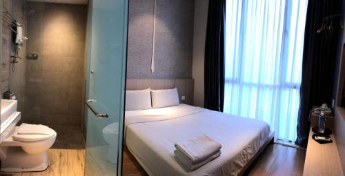 a small bathroom with a bed and a toilet at Kyoto Boutique Hotel in Johor Bahru