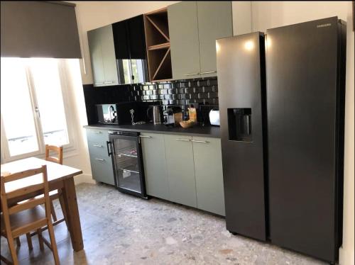 une cuisine avec un réfrigérateur en acier inoxydable et une table dans l'établissement Somptueux appartement Beau-Rivage, à Annecy