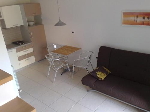 a living room with a couch and a table and chairs at Apartments Villa Ina in Brseč