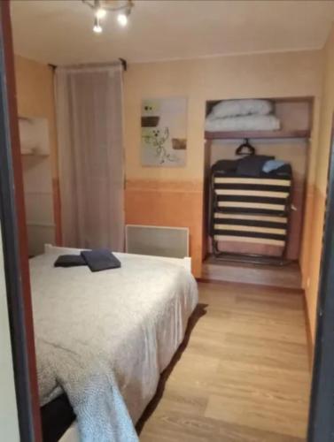 - une chambre avec un lit et un portant dans l'établissement Appartement avec stationnement, à Champlitte-et-le-Prélot