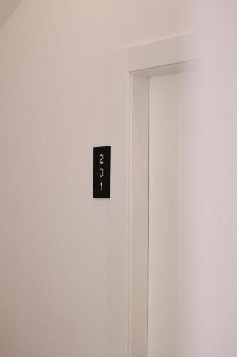 a door with a light switch on the wall at Emar Hotel in Tirana