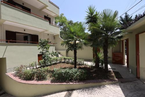 a house with two palm trees in front of it at Emar Hotel in Tirana