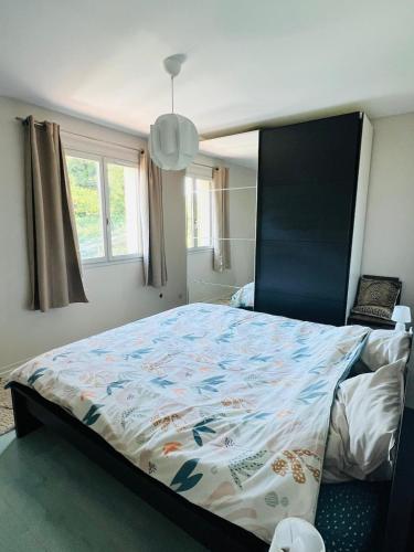 - une chambre avec un grand lit et une couette colorée dans l'établissement Maison entre lacs et fôrets, à Montréal La Cluse